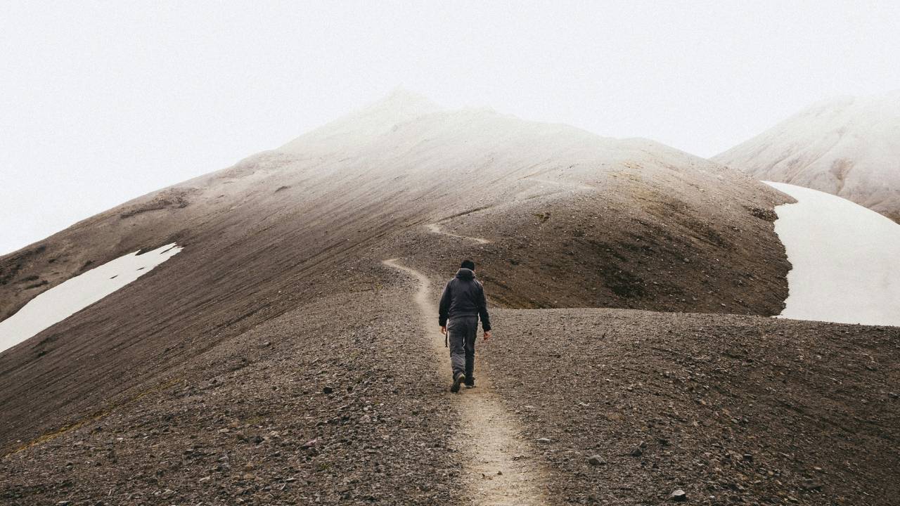 A person hiking over the foggy hills