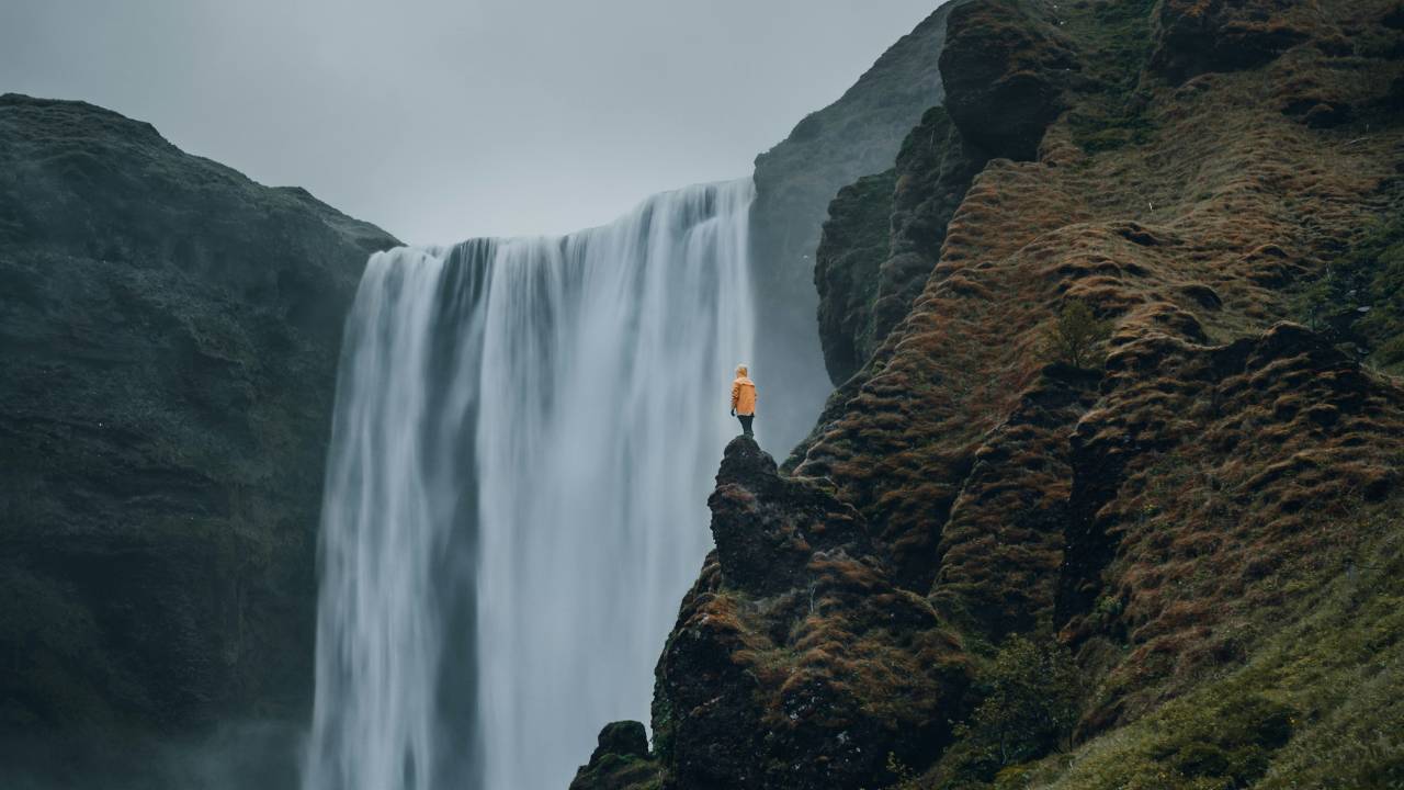 A man standing next to a waterfall